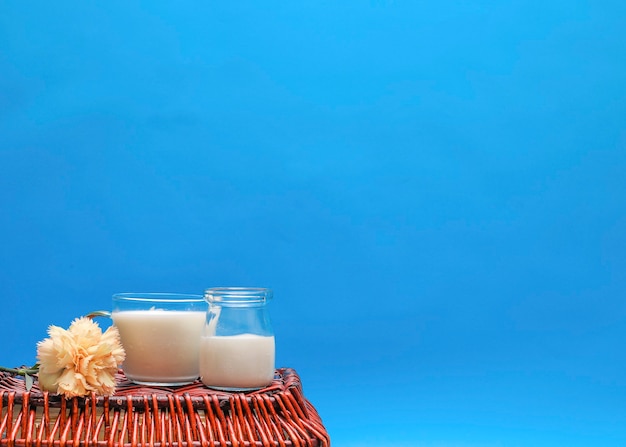 Vorderansicht der Milch in Tassen mit Blumen- und Kopienraum