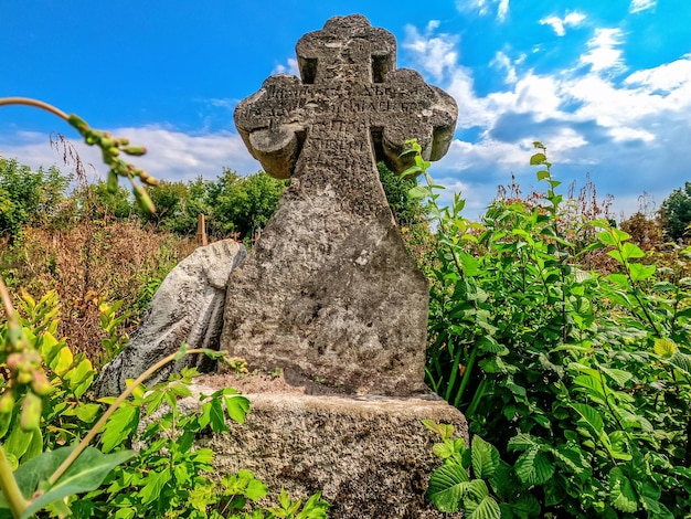 Vorderansicht des alten Steinkreuzes auf einem verlassenen Friedhof Antike Denkmäler
