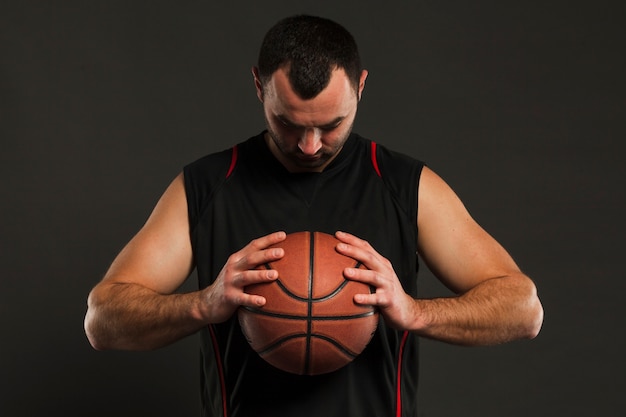 Foto vorderansicht des basketballspielers aufwerfend beim betrachten des balls