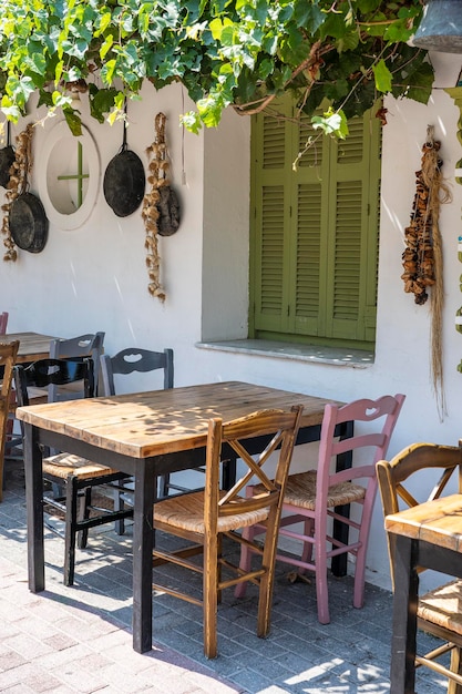 Vorderansicht des kleinen Cafés außen Tisch und leere Stühle im Freien in der Nähe der weißen Wand Touristische Orte Typisches mediterranes Restaurant ein Ort, an dem im Sommer Urlaub gemacht wird