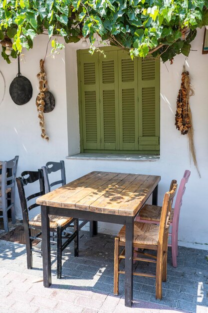 Vorderansicht des kleinen Cafés außen Tisch und leere Stühle im Freien in der Nähe der weißen Wand Touristische Orte Typisches mediterranes Restaurant ein Ort, an dem im Sommer Urlaub gemacht wird