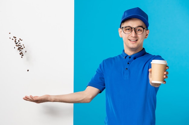 Vorderansicht des männlichen Kuriers in Uniform mit Kaffee auf Blau