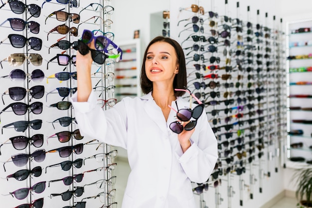 Foto vorderansicht des optikers sonnenbrillepaare halten