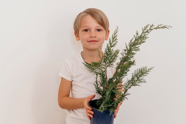 Vorderansicht des Smileyjungen, der Topf der Pflanze hält