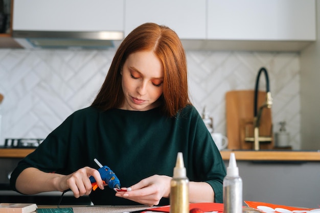 Vorderansicht einer attraktiven jungen Frau, die Umschläge an Bord mit Geschenken für die Herstellung von Kindern klebt