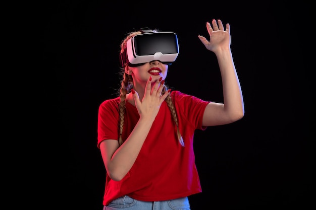 Vorderansicht einer jungen Frau, die virtuelle Realität auf einem dunklen Ultraschallspiel spielt