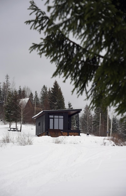 Foto vorderansicht einer modernen schwarzen winzigen kabine auf schneebedeckten bergen