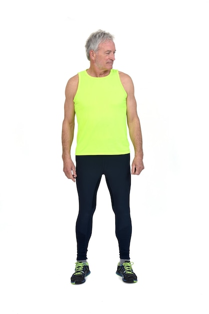 Vorderansicht eines Mannes in Sportstrumpfhosen und fluoreszierendem gelben Ärmellos, der auf weißen Hintergrund herabblickt