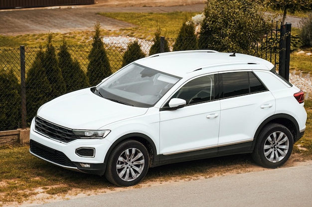 Foto vorderansicht eines weißen europäischen mittelgroßen sport utility vehicle, das in einem vorort geparkt steht. familien-lkw. modernes auto