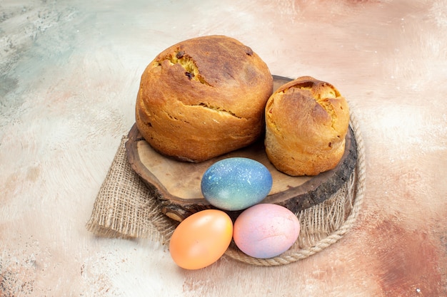 Vorderansicht farbige ostereier mit ostern backen auf heller oberfläche osterfeiertag verzierte multiethnische bunte gruppenfarben