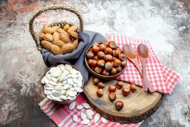 Vorderansicht frische Haselnüsse mit weißen Samen und Pekannüssen auf weißem Hintergrund Nusspflanze Foto Küchenbaum Walnuss Erdnuss cips