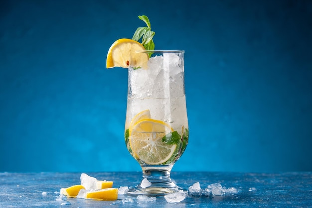 Vorderansicht frische kühle Limonade mit Eis und Zitrone auf blauem Hintergrund Fruchtwasser-Cocktailgetränk Farbe Bar Saft kalt