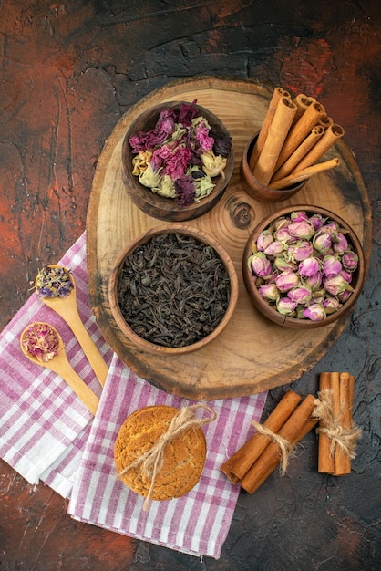 Vorderansicht frischer schwarzer Tee mit Keksen und Blumen auf dunklem Hintergrund Aroma Tee Farbfoto Blume Kaffeegetränk