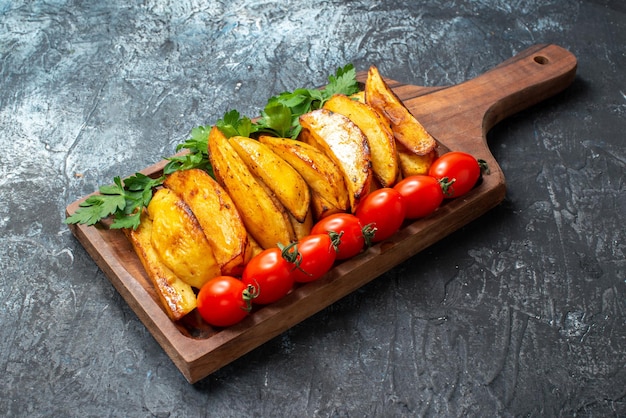 Vorderansicht gebratene leckere Kartoffeln mit Gemüse und Tomaten auf dunklem Hintergrund Mahlzeit Abendessen Fleischsalat Foto Tomatengericht