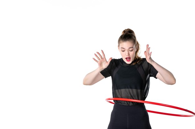 Vorderansicht junge Frau, die mit rotem Hula-Hoop auf weißem Hintergrund arbeitet Yoga Körperfarbe Lifestyle Gesundheit Sport Athlet Frau