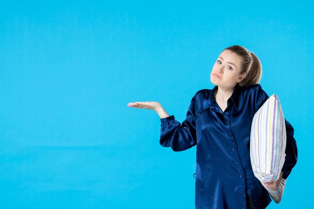 Vorderansicht junge Frau im Pyjama mit Kissen auf blauem Hintergrund Alptraum Party Farbe Traum Gähnen Schlaf Nachtruhe Frau Bett