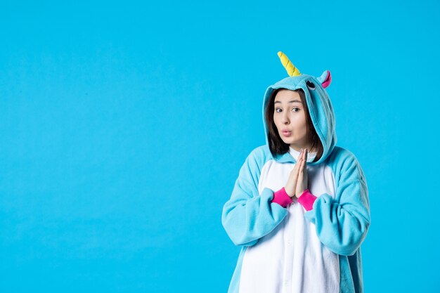 Vorderansicht junge Frau in Kigurumi für Pyjama-Party auf blauem Hintergrund Ruhe Cartoon Traum Schlaf Farbe Späte Spaß Nacht Freunde Anime Bett Spiele