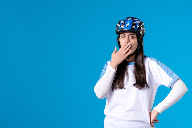 Vorderansicht junge Frau in Sportkleidung mit Helm auf blauer Wand