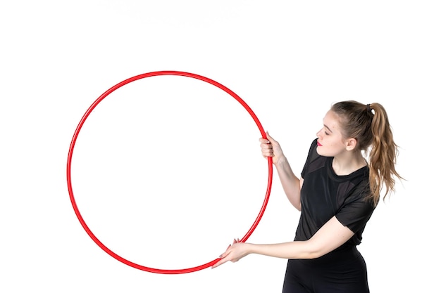 Vorderansicht junge Frau mit rotem Hula-Hoop auf weißem Hintergrund Farbe Yoga Körper Lifestyle Athlet Zirkus Sport Frau Gesundheit