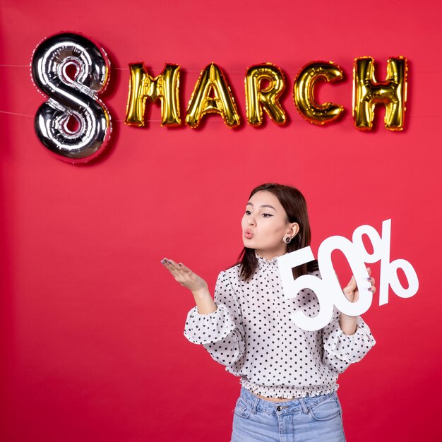 Vorderansicht junge weibliche Holdingschrift auf März dekoriert roten Hintergrund Shopping Schönheit Urlaub liebevolle Gleichberechtigung Frau Mall