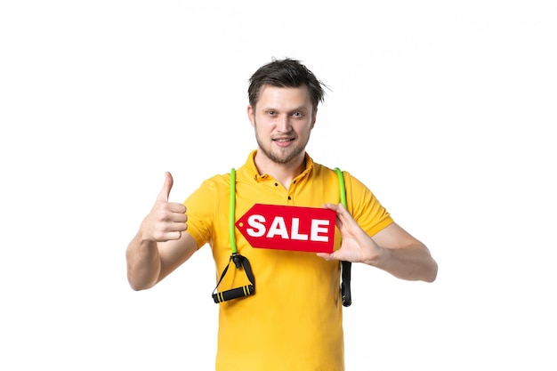 Vorderansicht junger Mann mit rotem Verkauf geschrieben Typenschild auf weißem Hintergrund Job Sport Mensch Einkaufen Verkäufer Arbeiter Uniform Geld