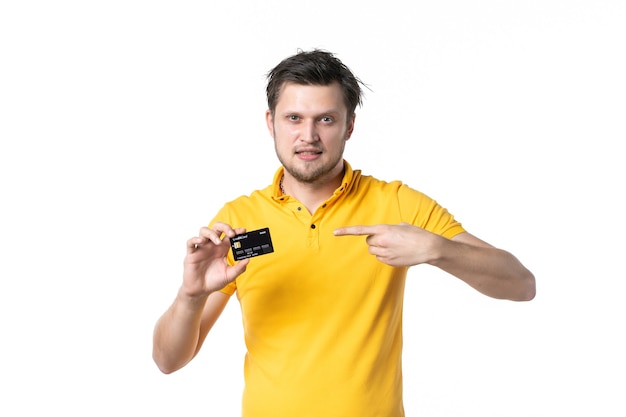 Vorderansicht junger Mann mit schwarzer Bankkarte auf weißem Hintergrund Fitnessstudio Job Sportverkäufer Uniform Geld einkaufen Gesundheit