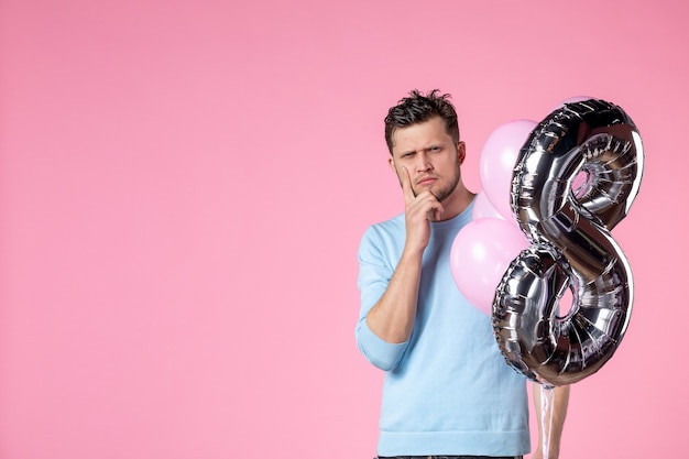 Vorderansicht junger Mann mit süßen Luftballons auf rosa Hintergrund Liebe feminine Frauentag Ehe Gleichstellung Datum März Park sinnlich