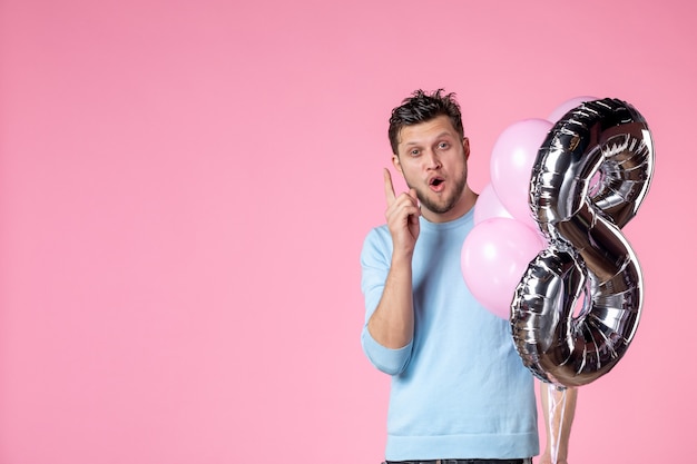 Vorderansicht junger Mann mit süßen Luftballons auf rosa Hintergrund Liebe feminine Frauentag Ehe Gleichstellung Datum März Park Spaß