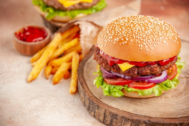 Vorderansicht köstliche Cheeseburger mit Pommes Frites auf Schneidebrett auf hellem Hintergrund Salat Fastfood Kartoffelsandwich Burger Snack