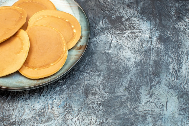 Vorderansicht köstliche kleine Pfannkuchen im Teller auf grauem Hintergrund Honig Zucker Frühstück Morgen Essen Familie backen Teig geleefreier Ort