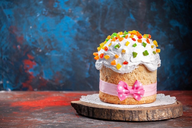 Vorderansicht köstlicher osterkuchen mit weißer creme und getrockneten früchten auf dunklem hintergrund frühling bunter nachtischkuchen backen verziertes konzept