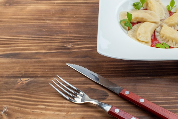 Vorderansicht lecker gebackene Hotcakes mit Tomatenmark im Teller auf braunem Hintergrund Kochservice Backen Küche Teig Restaurant