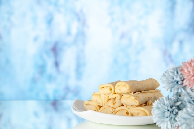 Vorderansicht lecker gerollte Pfannkuchen auf hellem Hintergrund Milchfrühstückskuchen Dessert Morgenblumenfarbe Zucker