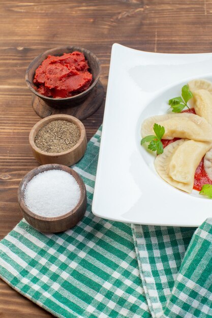 Vorderansicht leckere Kartoffel-Hotcakes mit Tomatenmark und Gewürzen auf braunem Hintergrund Kochen backen Küche Restaurant Pasta Teig