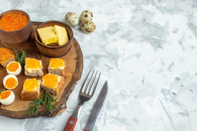 Vorderansicht leckere Kaviar-Sandwiches mit gekochten Eiern auf Holzbrett weißer Hintergrund Frühstück Essen Mahlzeit Meeresfrüchte Fisch Mittagessen Toastbrot