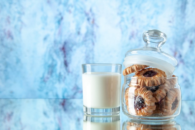 Vorderansicht leckere Kekse in der Dose mit Glas Milch auf heller Hintergrundfarbe Zucker Frühstück morgens süßer Keks Dessertkuchen