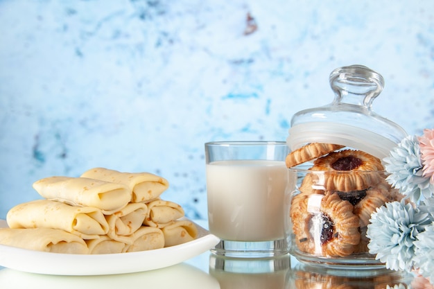 Vorderansicht leckere Pfannkuchen mit Keksen und Milch auf dem hellen Hintergrund Zucker Dessert Farbe Keks süße Frühstücksmahlzeit Kuchen Morgen