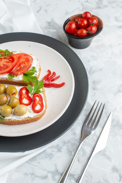 Vorderansicht leckere sandwiches mit tomaten und oliven im teller weiß