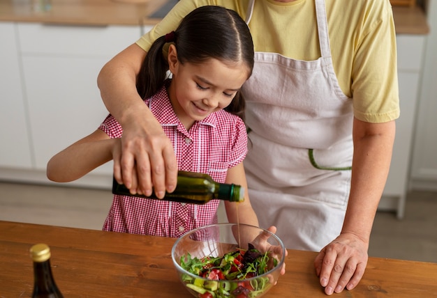 Foto vorderansicht oma und mädchen, die zusammen kochen