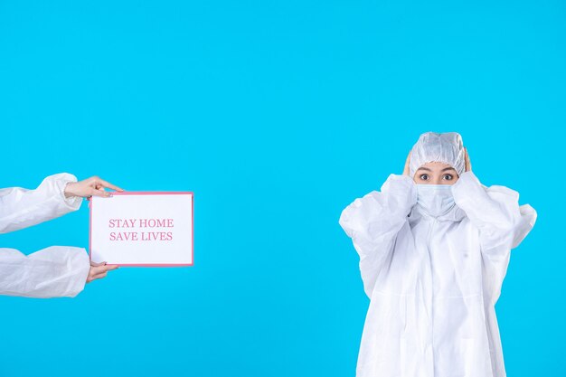 Vorderansicht Ärztin in Schutzanzug und Maske auf blauem Hintergrund Isolation Covid-Wissenschaft pandemische Gesundheit Virus Medizin