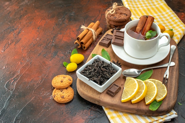 Vorderansicht Tasse Tee mit Schokoladen- und Zitronenscheiben auf dunklem Hintergrund Kakao Frühstückszeremonie Tee Fruchtfarbe süß