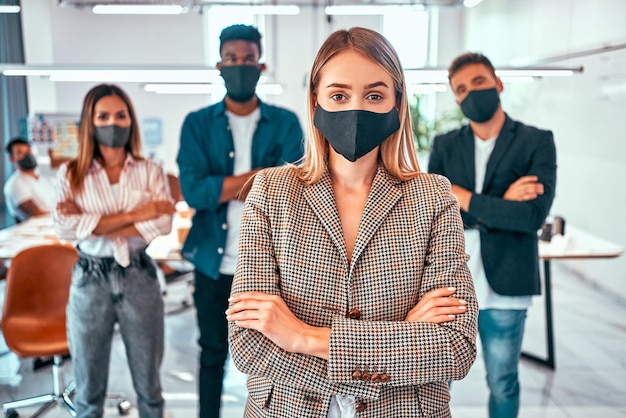 Vorderansicht von Geschäftsleuten, die während der Quarantänezeit Schutzmasken im Büro tragen