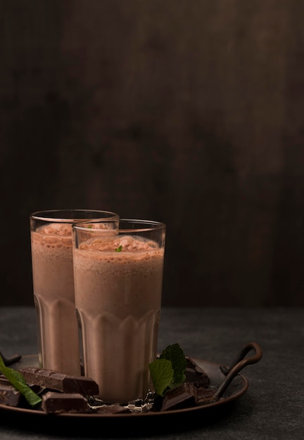 Foto vorderansicht von milchshake-gläsern mit schokolade und kopienraum