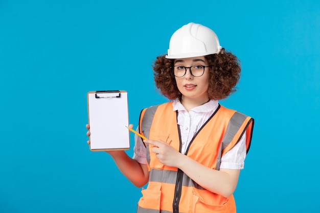 Vorderansicht weiblicher Baumeister in der Uniform auf dem Blau