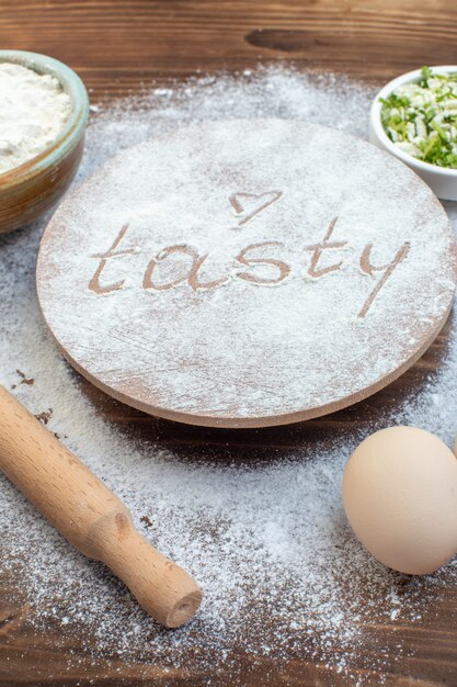 Vorderansicht Weißmehl mit Eiern und Nudelholz auf braunem Hintergrund Fleisch kochen Backen Mahlzeit lecker Ölkuchen Gebäck Teig