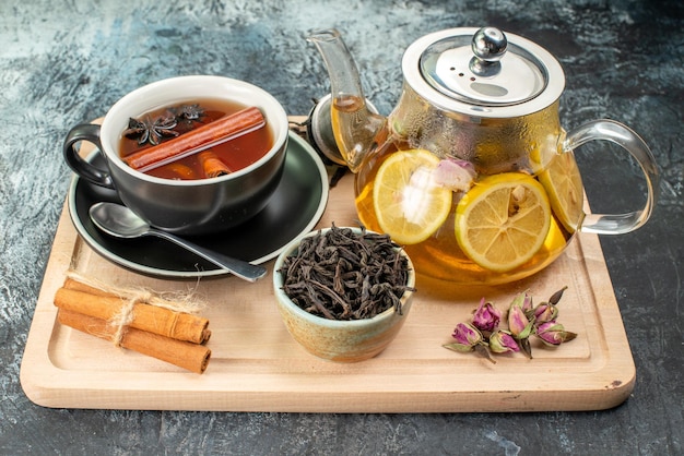 Vorderansicht Zitronentee in Tasse und Wasserkocher auf grauem Hintergrund Obstfrühstückszeremonie Farbfoto Essen Morgen