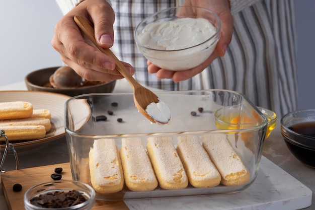 Vorderansichtkoch, der leckeres tiramisu kocht