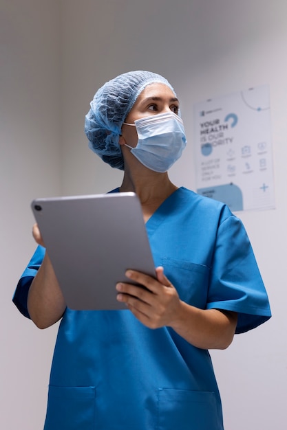 Foto vorderansichtkrankenschwester, die tablette hält