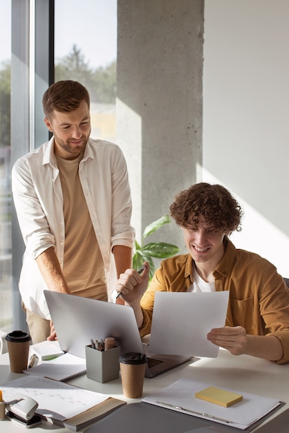 Foto vorderansichtleute, die mit laptop arbeiten