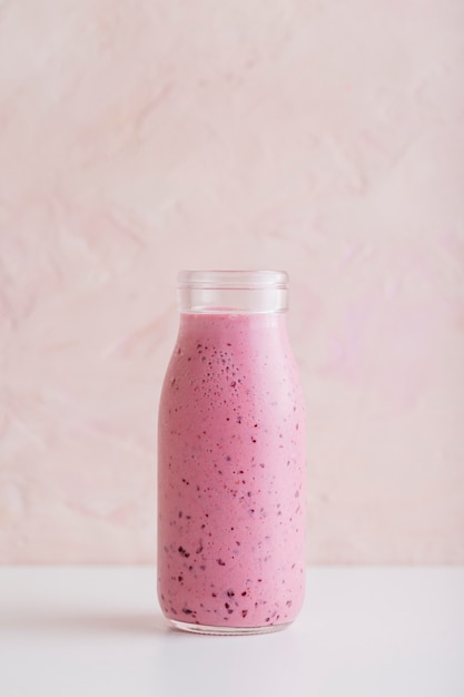 Foto vordere ansicht rosa smoothie-flasche mit kopierraum